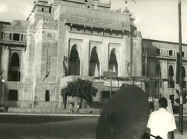 an old po shows a woman and child walking in front of a large building