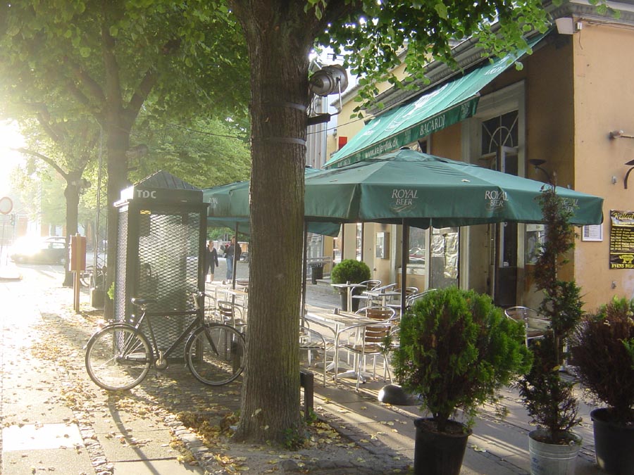 bicycles are parked outside a cafe that has green awnings