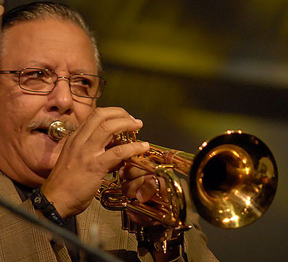 a man with glasses playing a trumpet