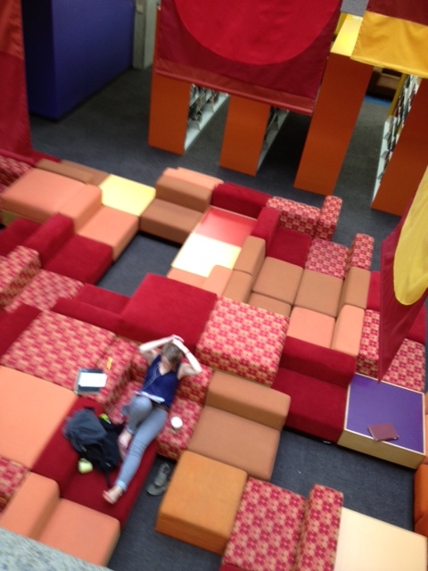 a person laying on a large, colorful couch in a room