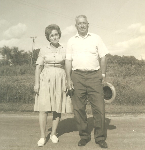 an old couple posing for a po next to an empty road