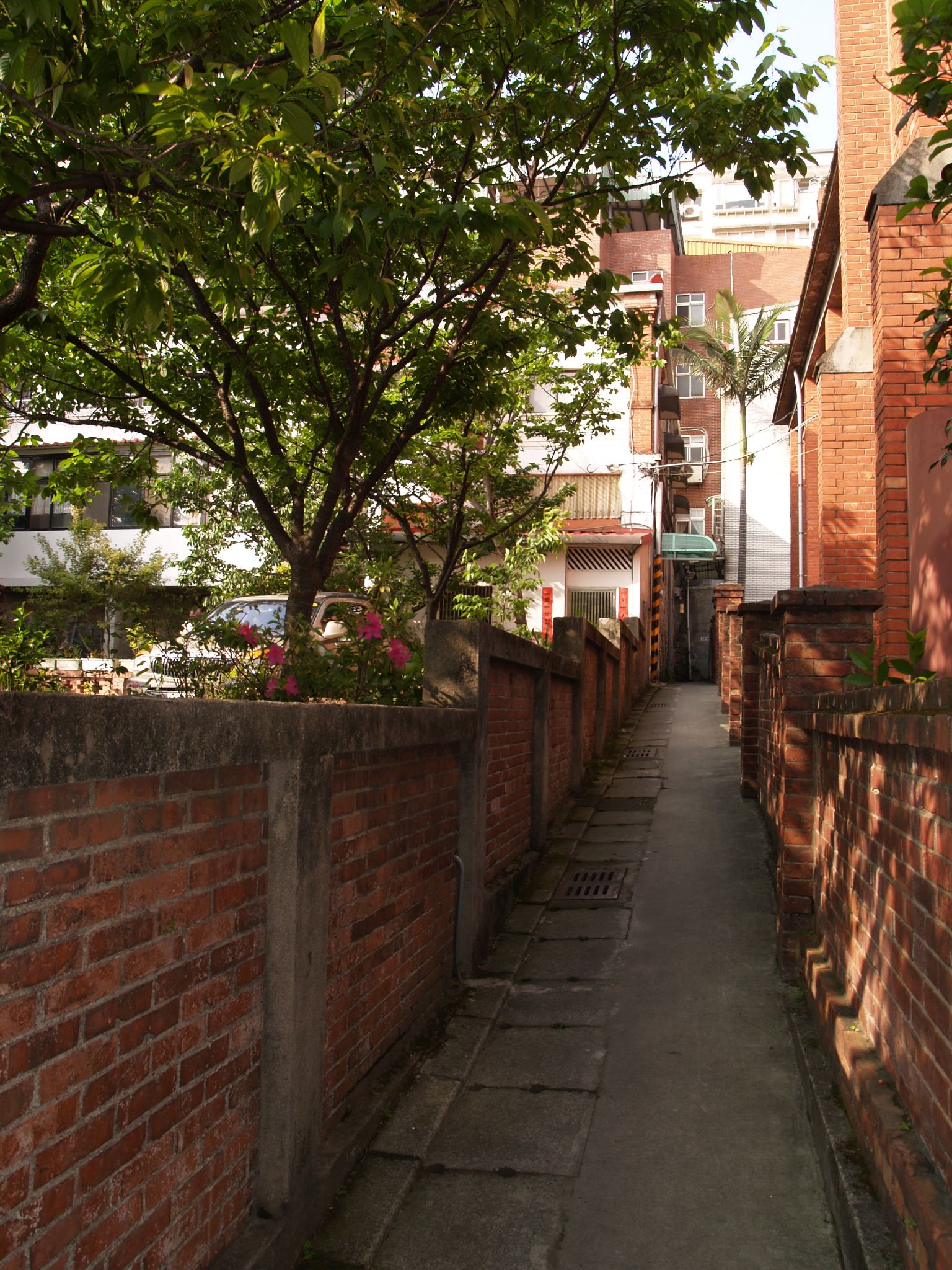 there is an alley between buildings with red bricks on it