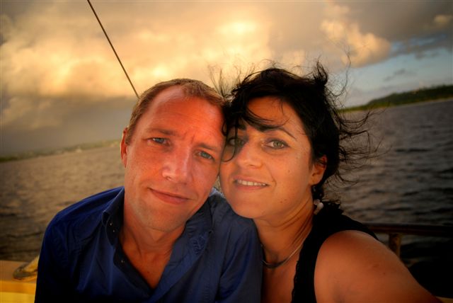 a smiling couple is posing on a boat