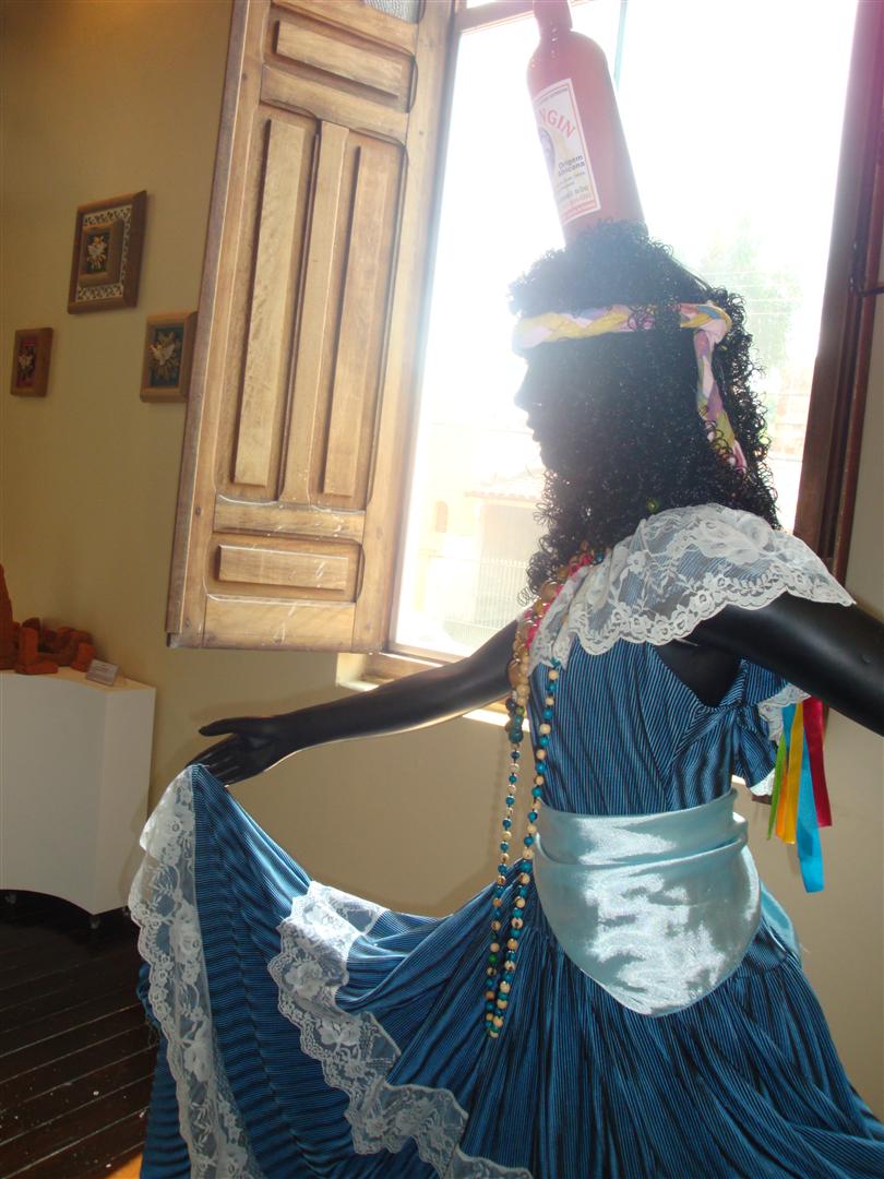 woman in blue dress with a big bottle on her head