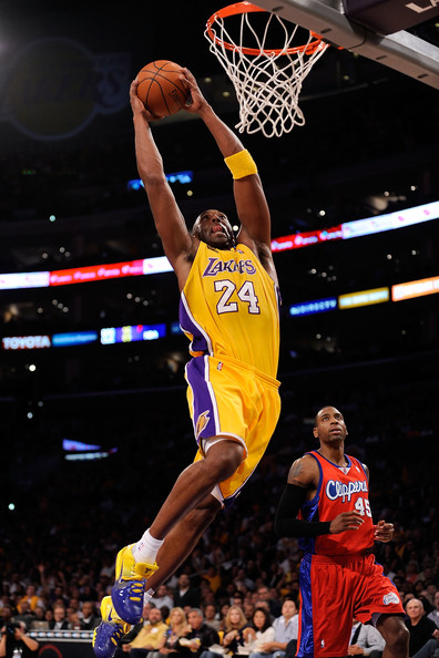 the lakers basketball player is jumping up for the dunk