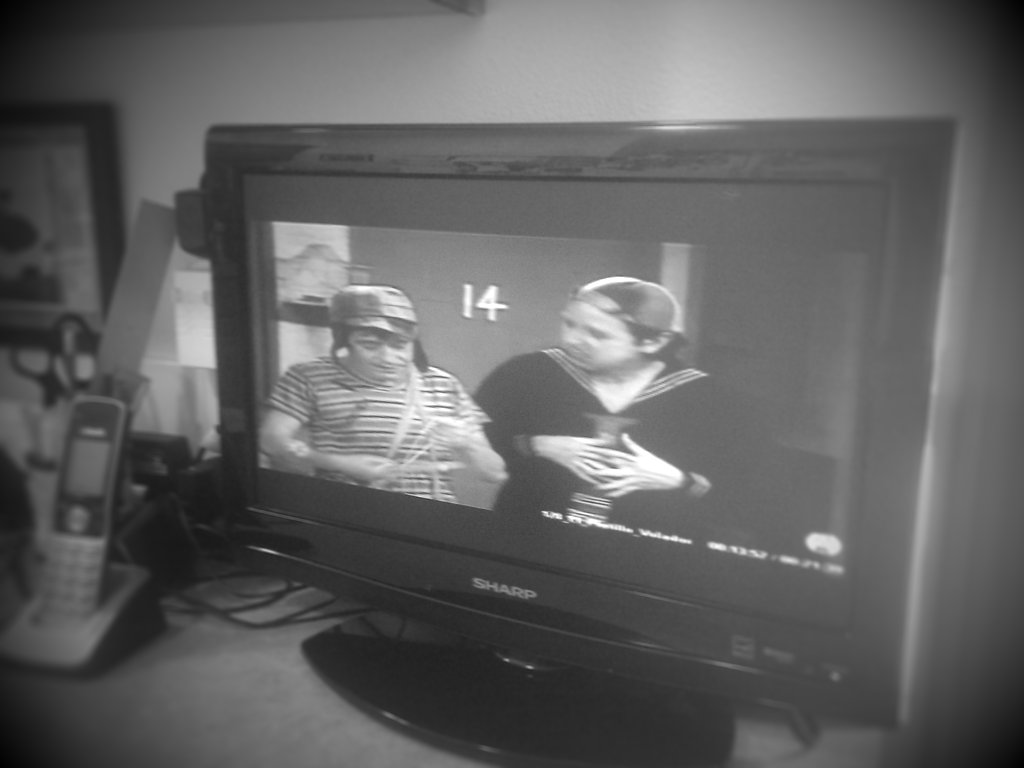 a black and white po of two people on a television screen