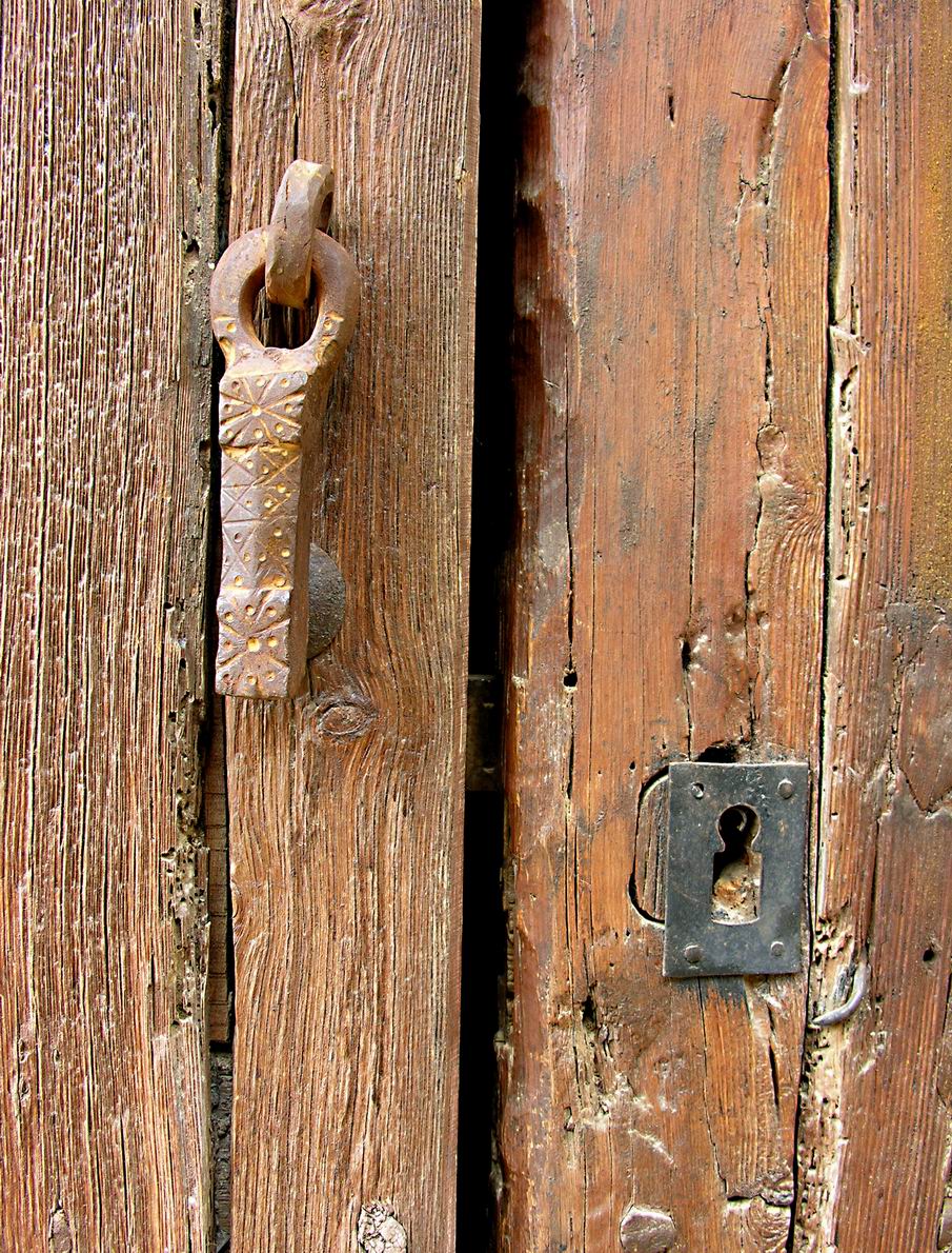 the latch on the side of an old weathered wooden door