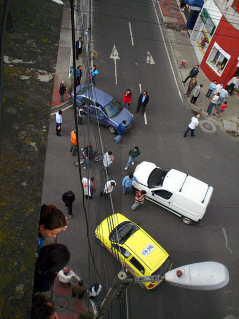 the small yellow car is pulled over onto the street