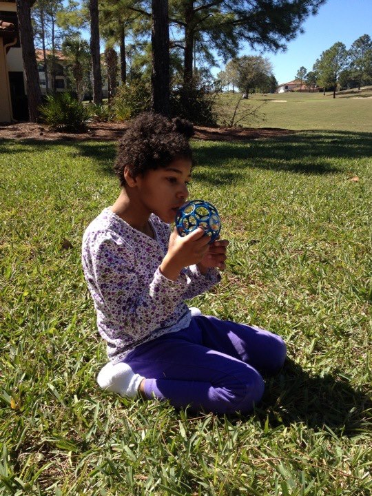  sitting on grass holding and playing with object