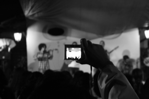 a person is holding up a cell phone to take a po of an audience