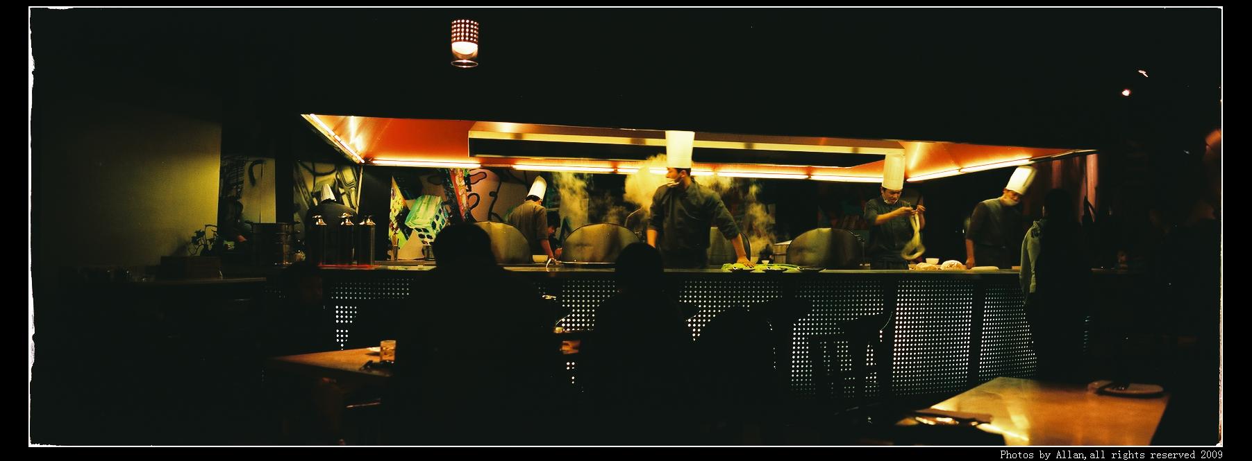 a group of people standing at the bar at night