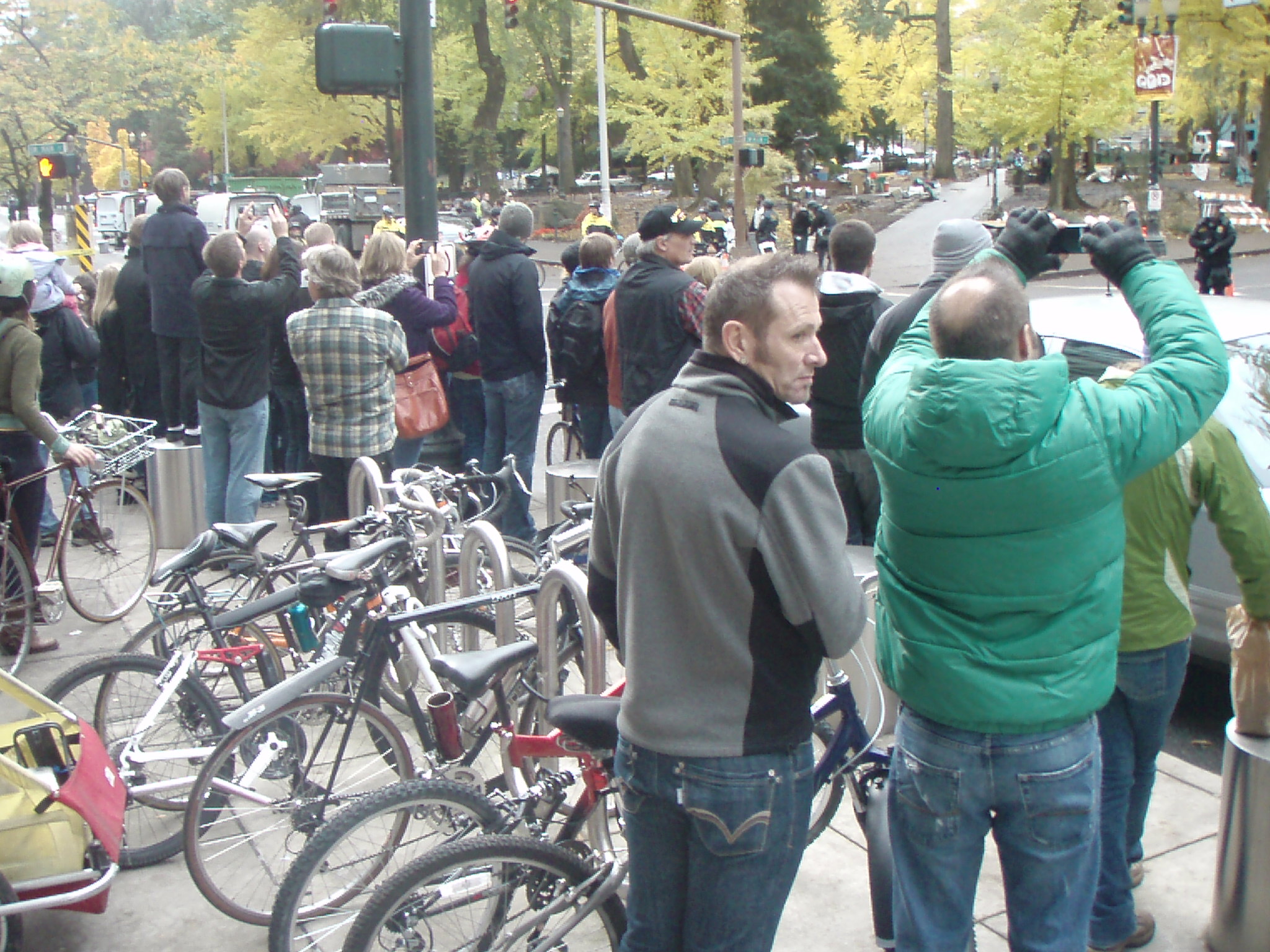 people are standing around a street looking at bicycles