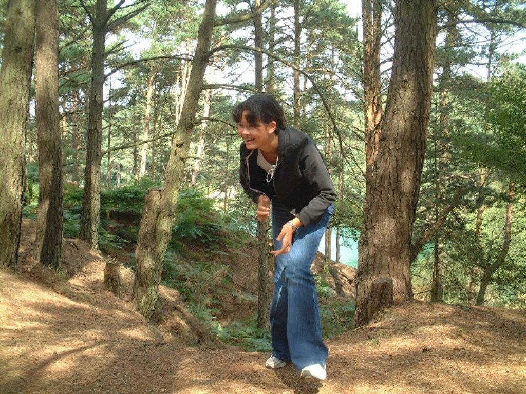 man in the woods about to skateboard down a hill