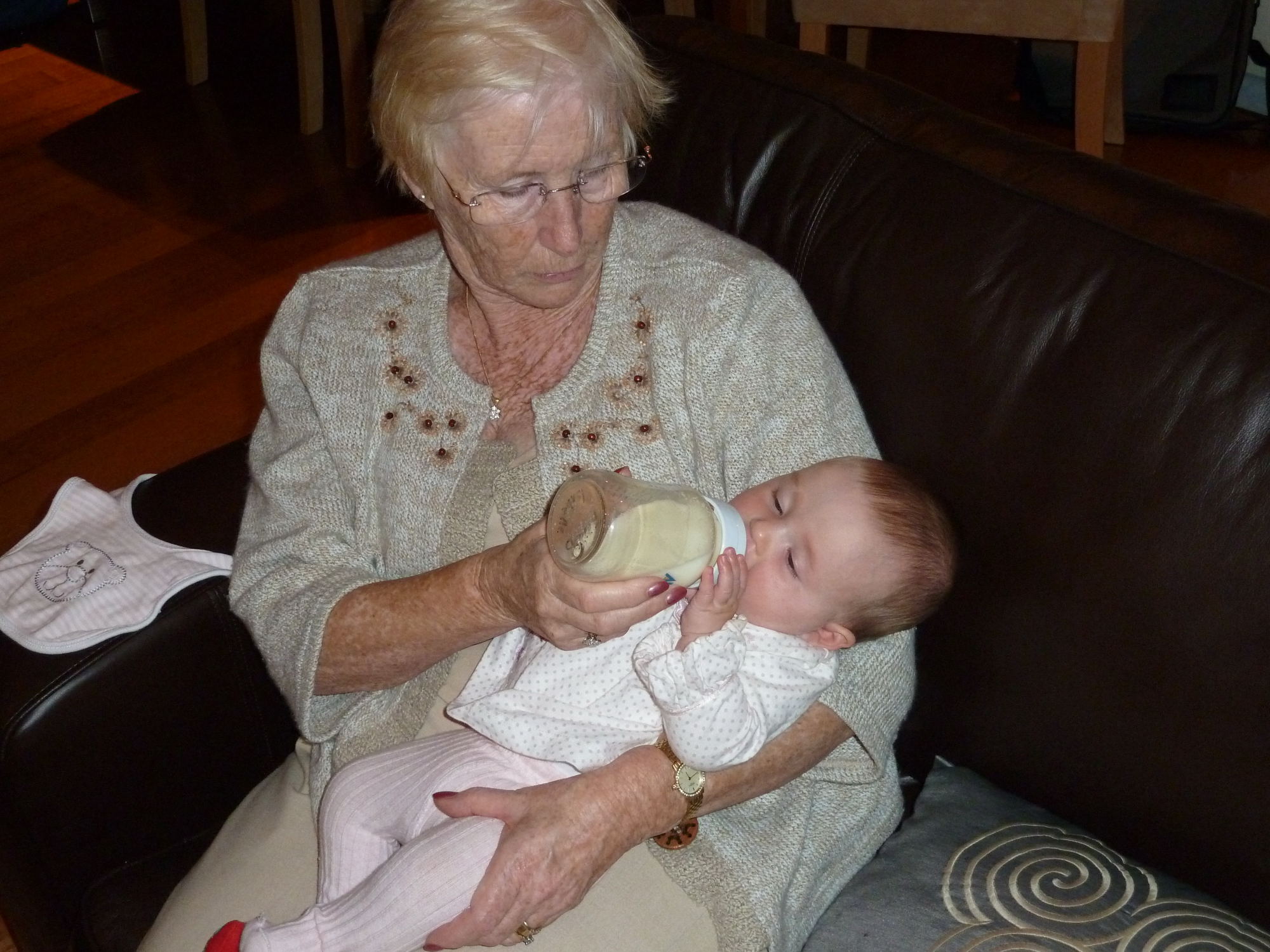 an older lady is feeding a baby soing