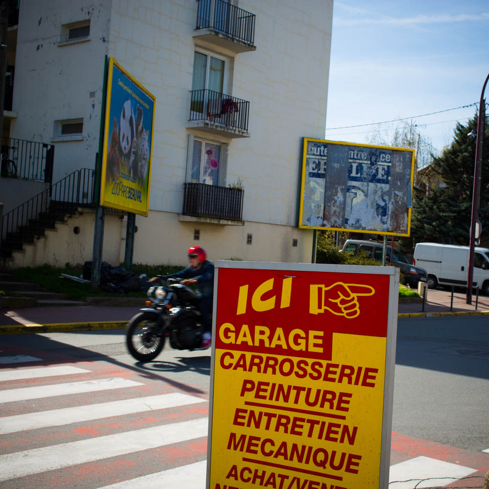 a motorcycle passing by a sign indicating it's going to be repaired