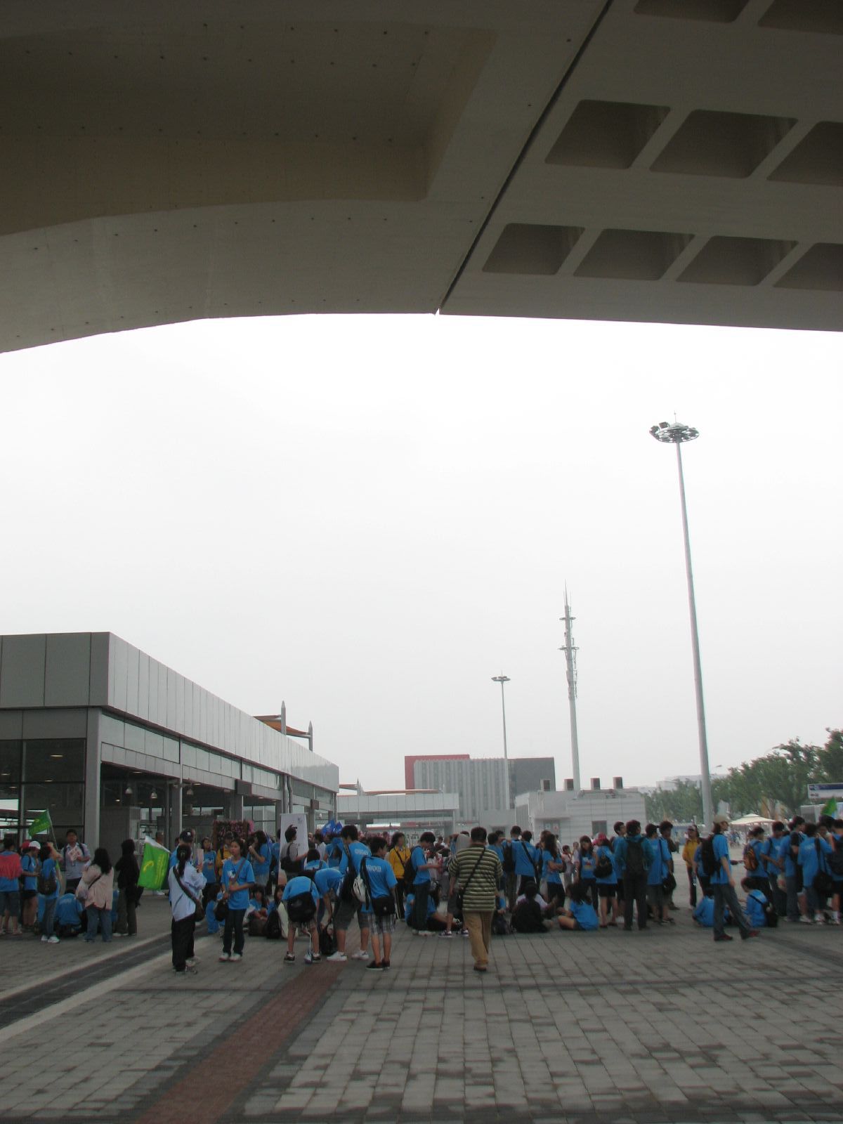 a crowd of people standing in a line by a building