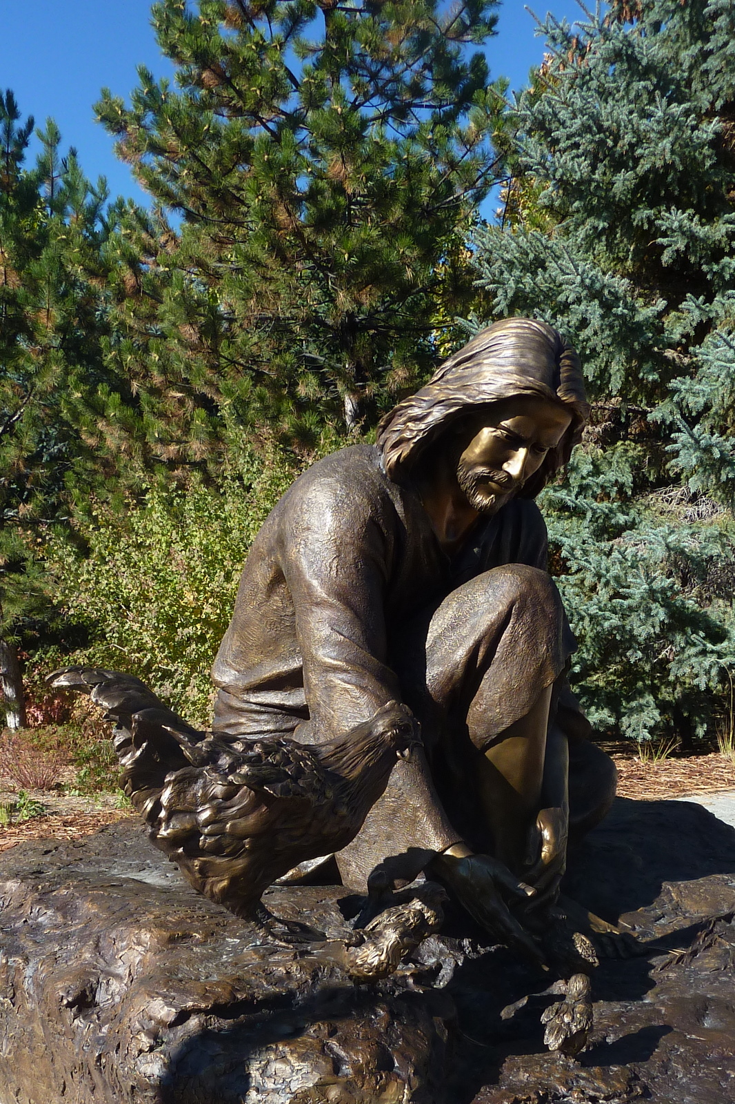 a statue of a child sitting on top of a rock