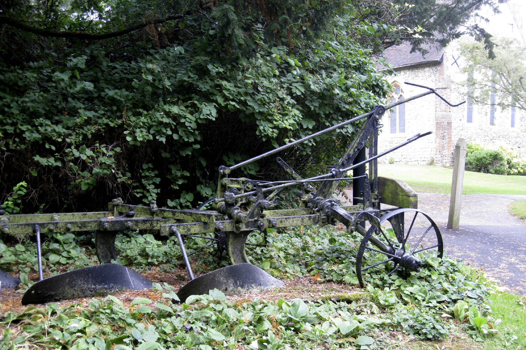 three old fashioned farm implements are lying on the ground