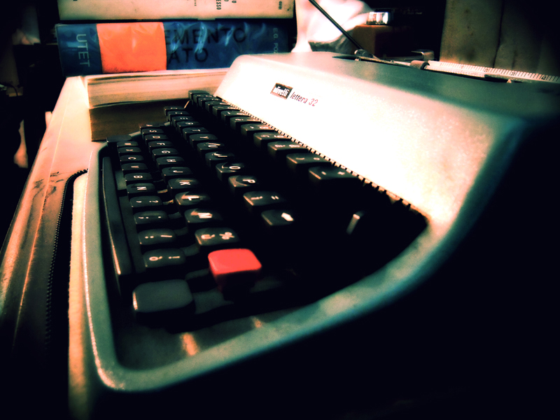 an old fashioned typewriter sitting next to books