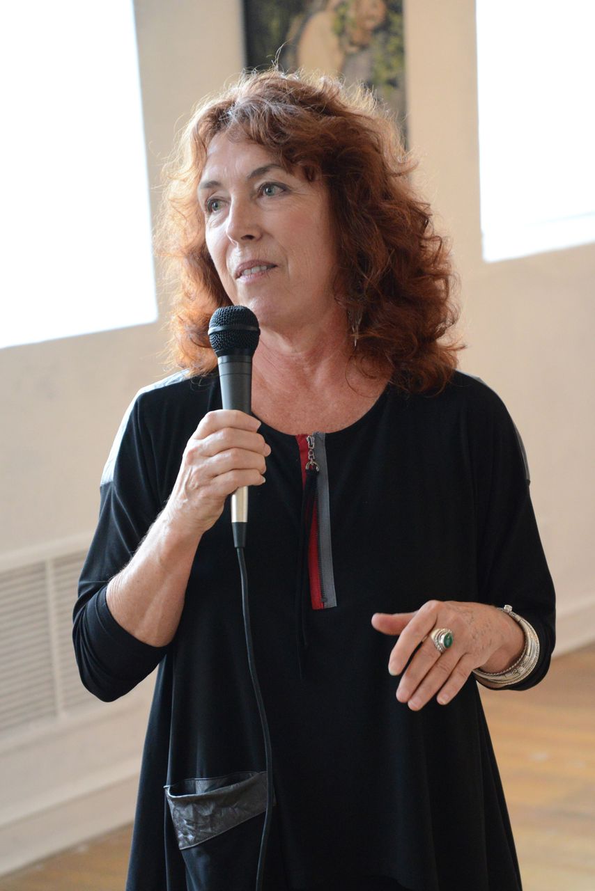 a woman is talking into a microphone with a ring on her finger