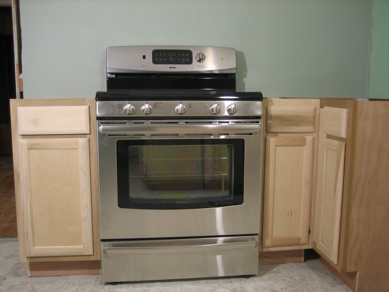 this kitchen features oak cabinets and a stainless steel stove with a microwave over it