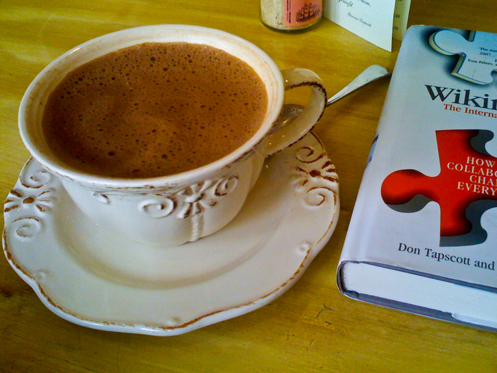 a close up of a coffee cup on a plate near a book