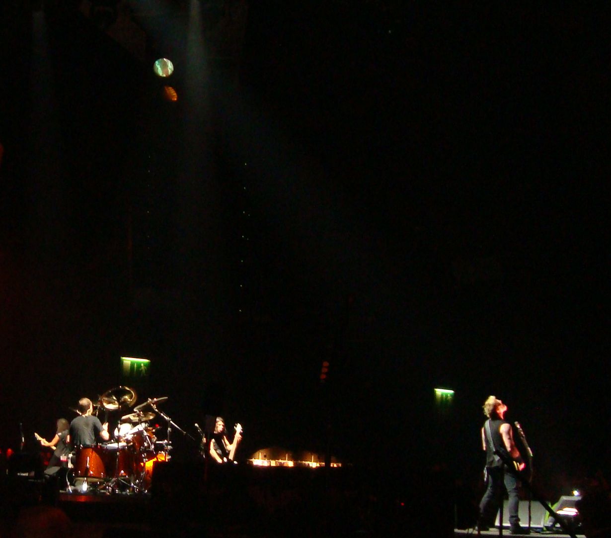 three people on stage performing in front of some microphones