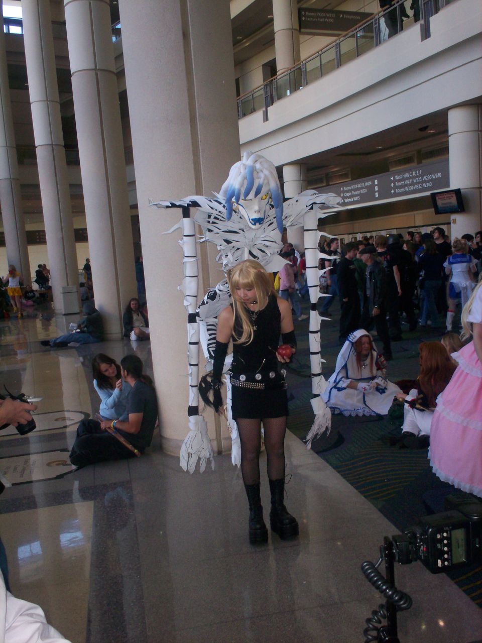 a woman dressed in black costume next to pillars