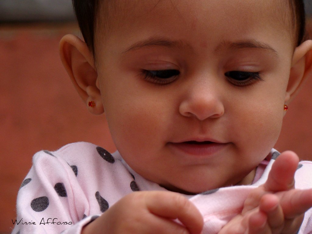 a young child putting soing on her thumb