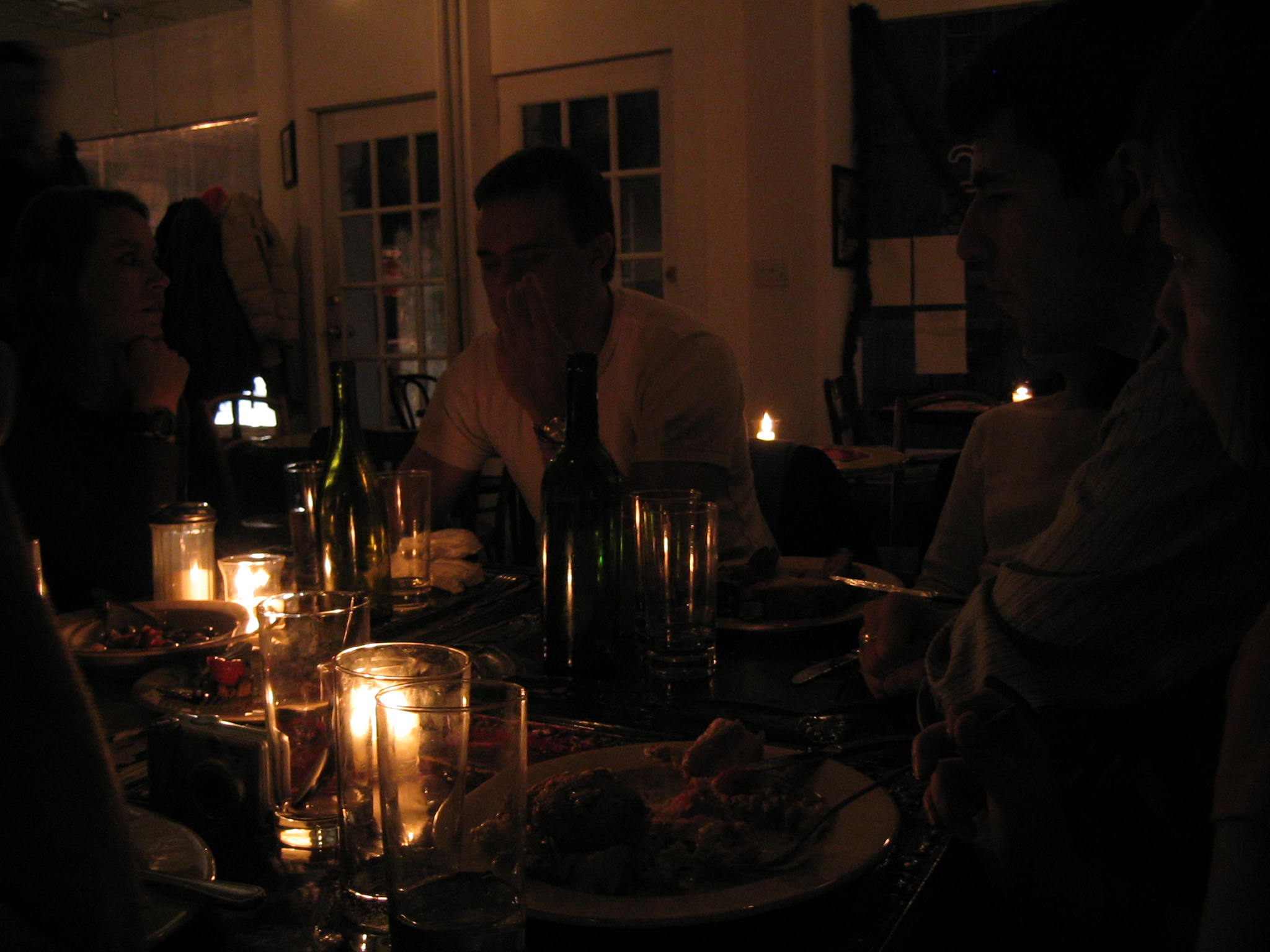 a woman is sitting on a table with a man while he is looking at a cell phone