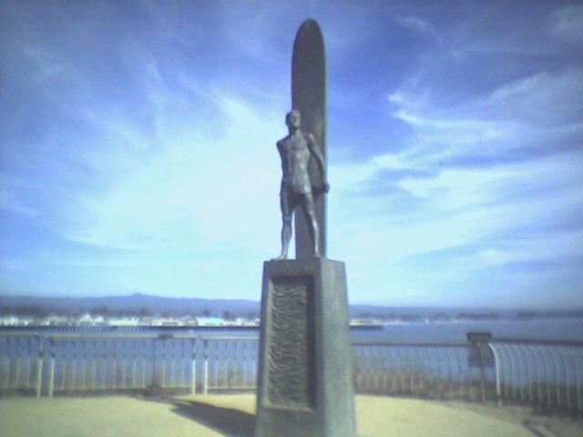 a statue with a surfboard in front of it