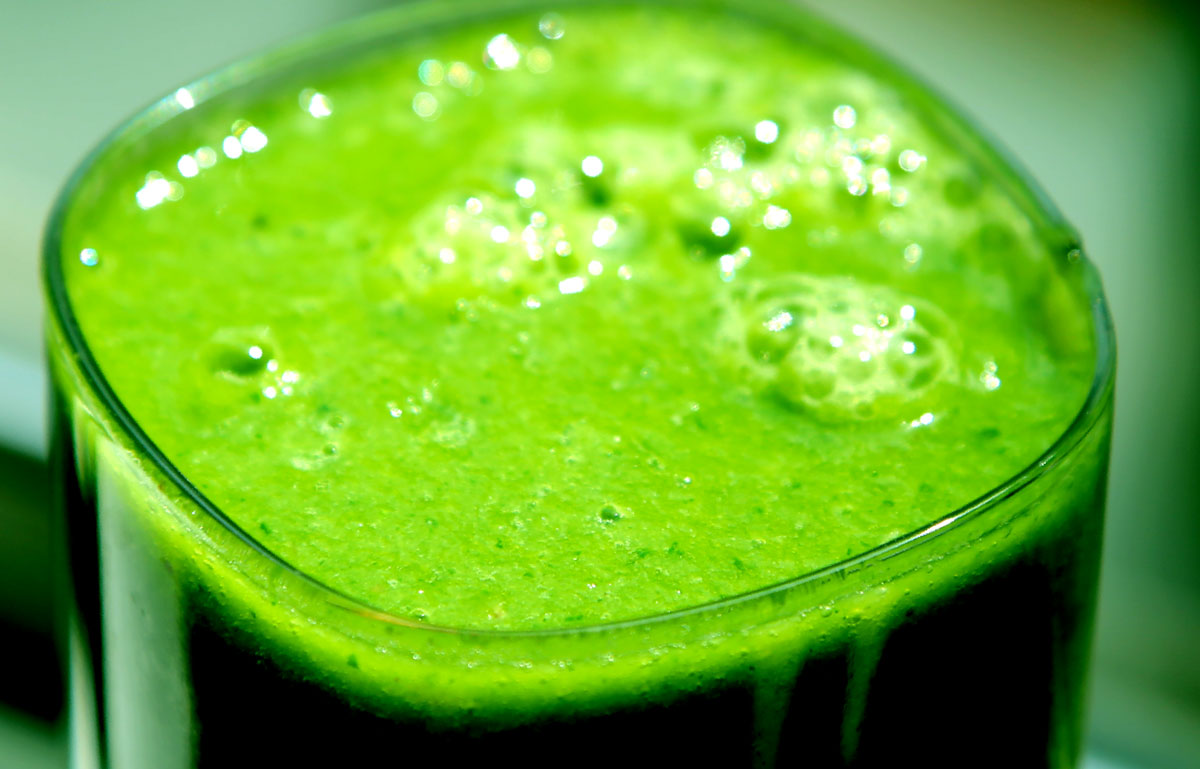 a green liquid sits inside a glass