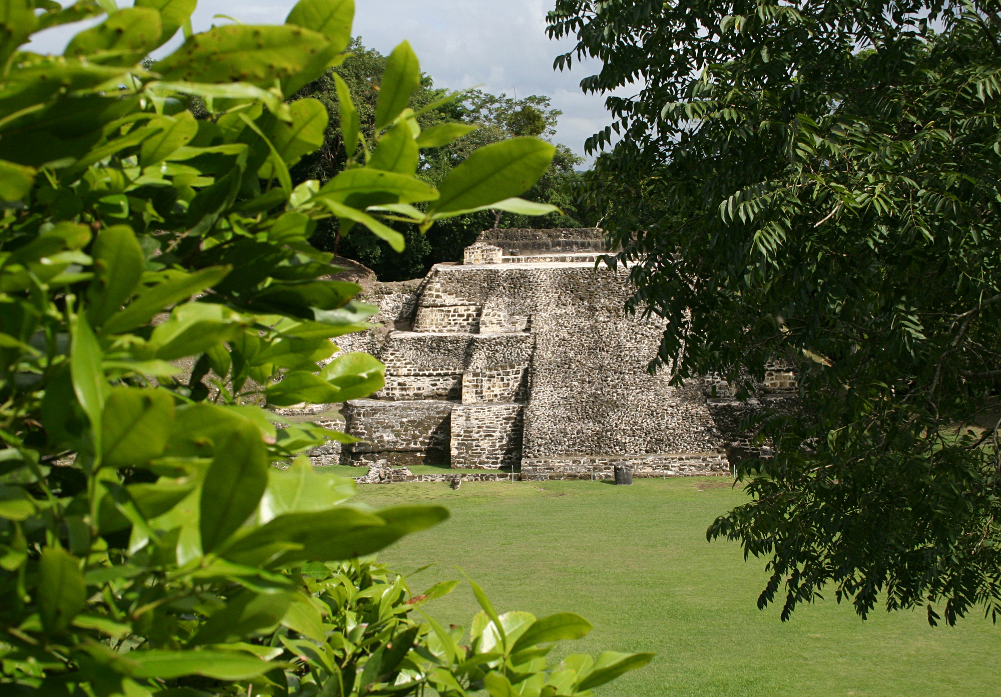 the view of a pyramid through trees to other buildings