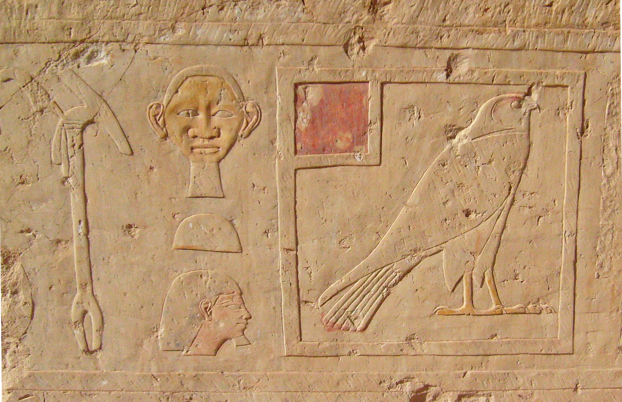 a egyptian wall relief showing the god, woman and man