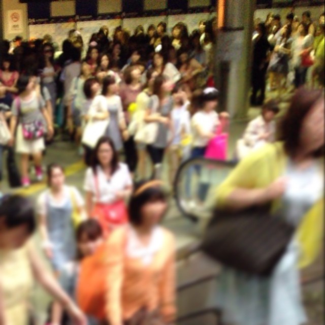 blurred s of crowd waiting to cross on a train platform