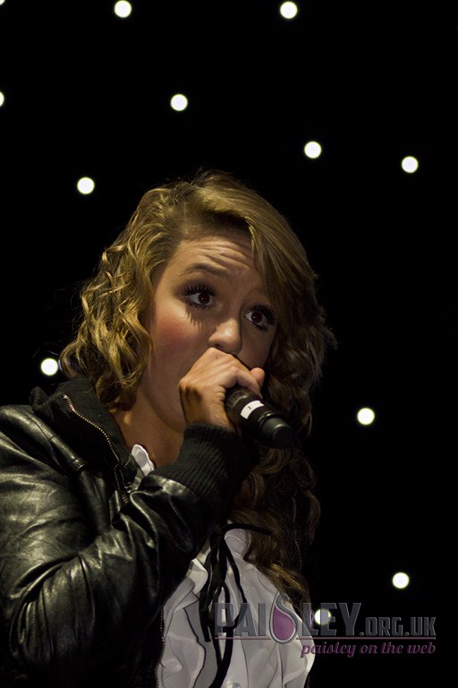 a beautiful young lady with long hair holding a microphone