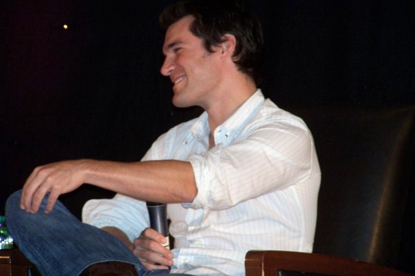 a man is sitting on a brown chair and smiling at someone