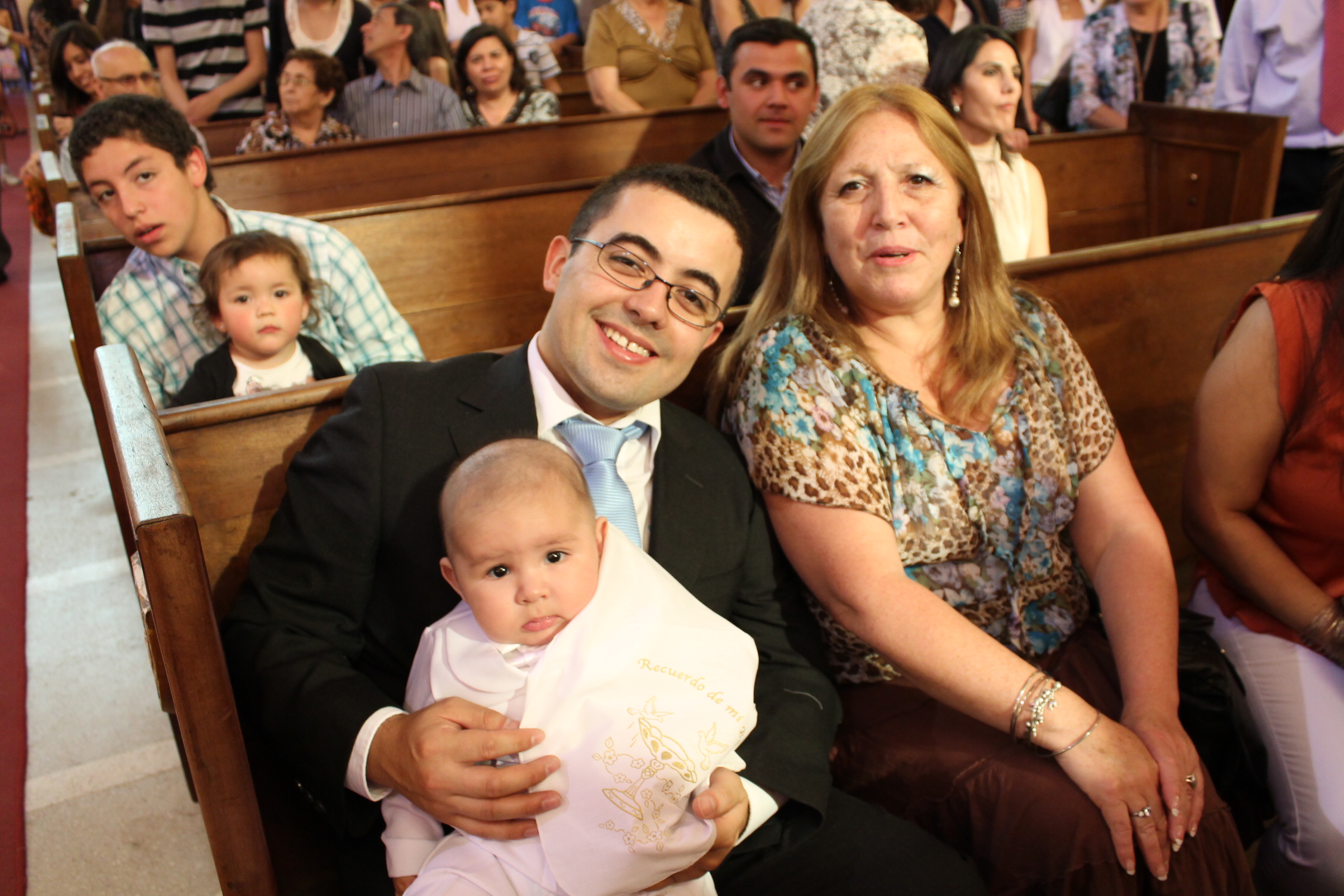 a man holding a baby on his lap in a church with a woman