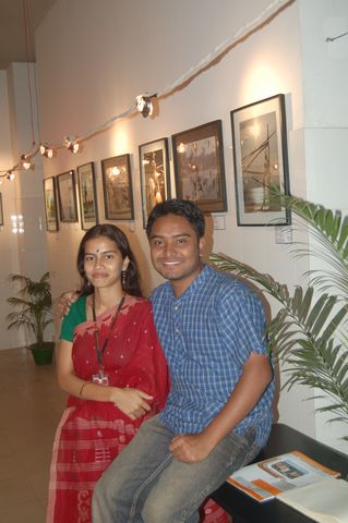 a man and woman sitting on a couch posing for the camera