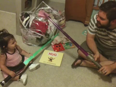 a father and daughter playing with a bat