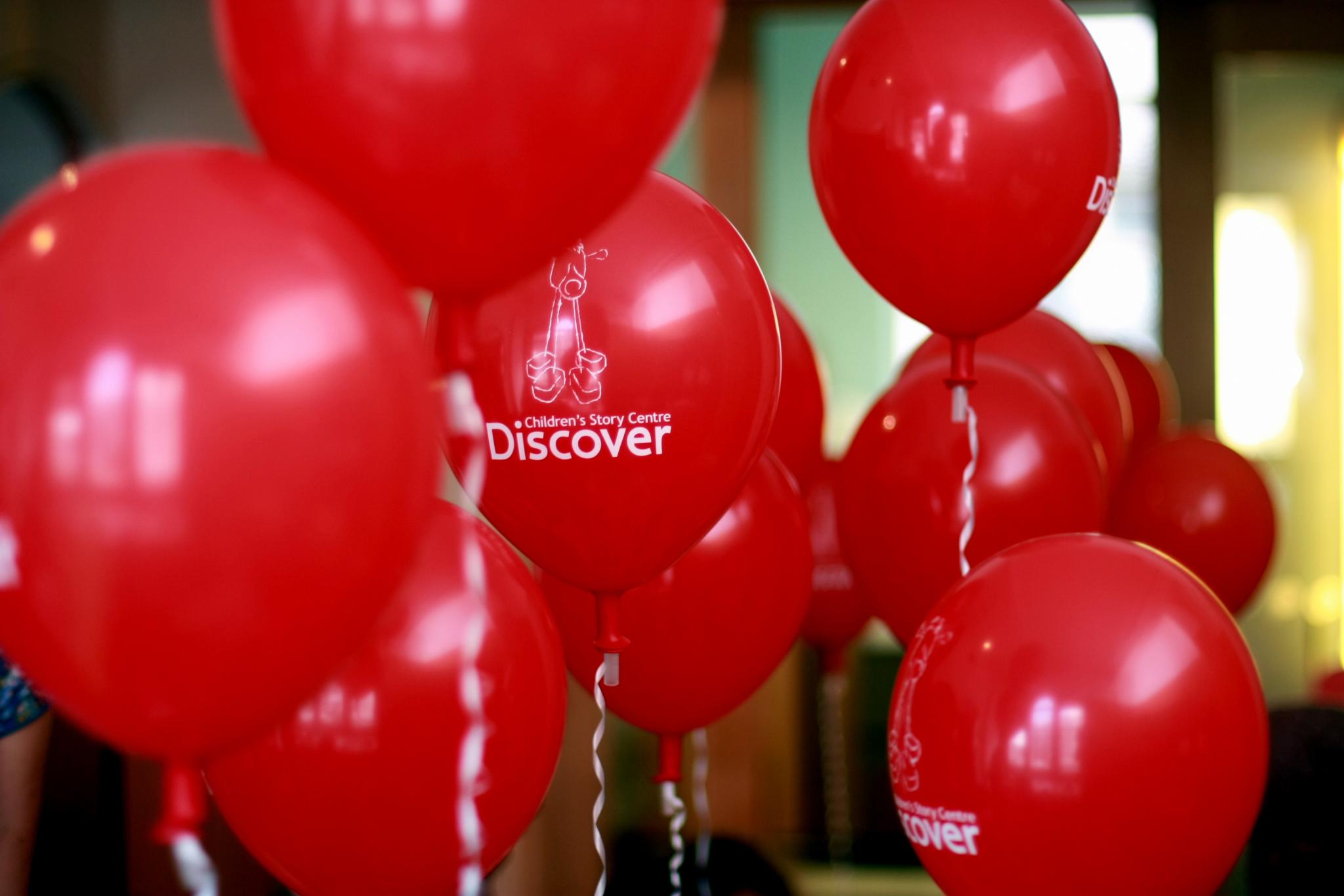 a bunch of red balloons are in a row