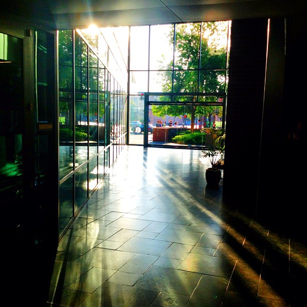 the sunlight is shining into a building lobby