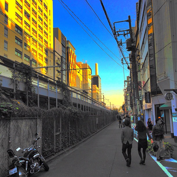 a man that is walking in the street near a motorcycle