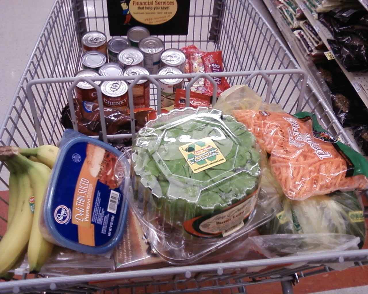 a grocery cart with food on it and condiments