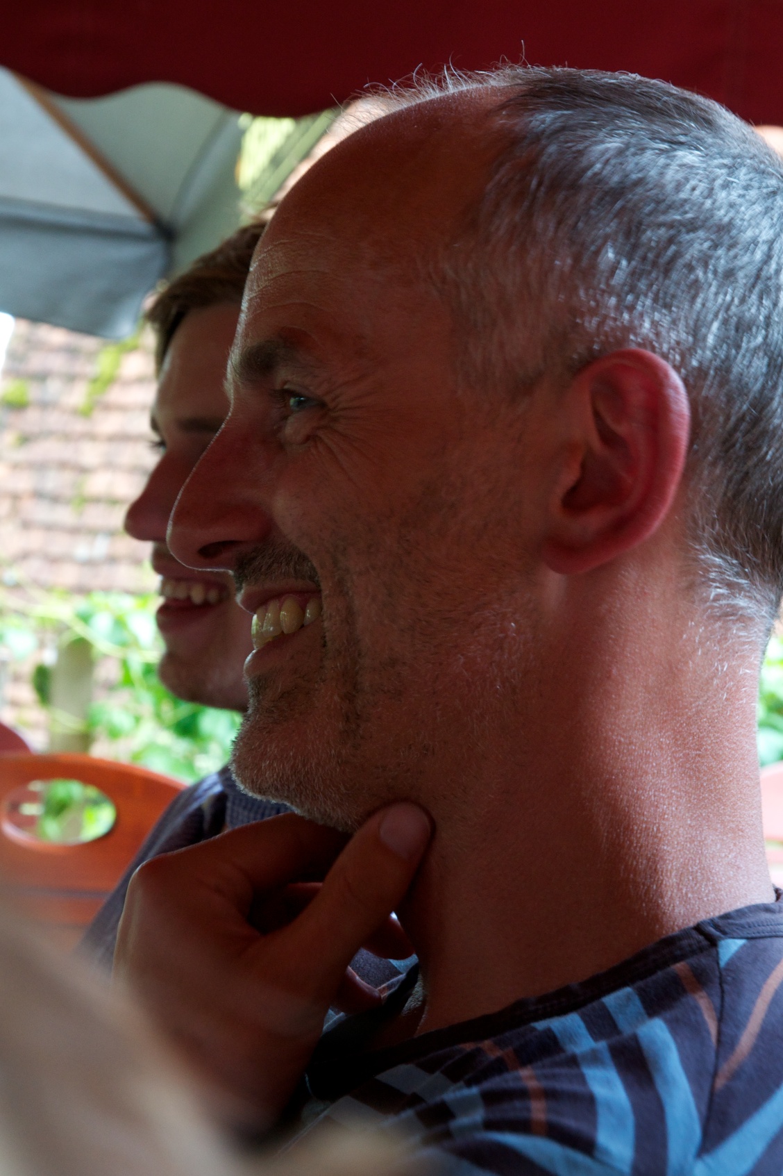 a smiling man is putting on his collar collar