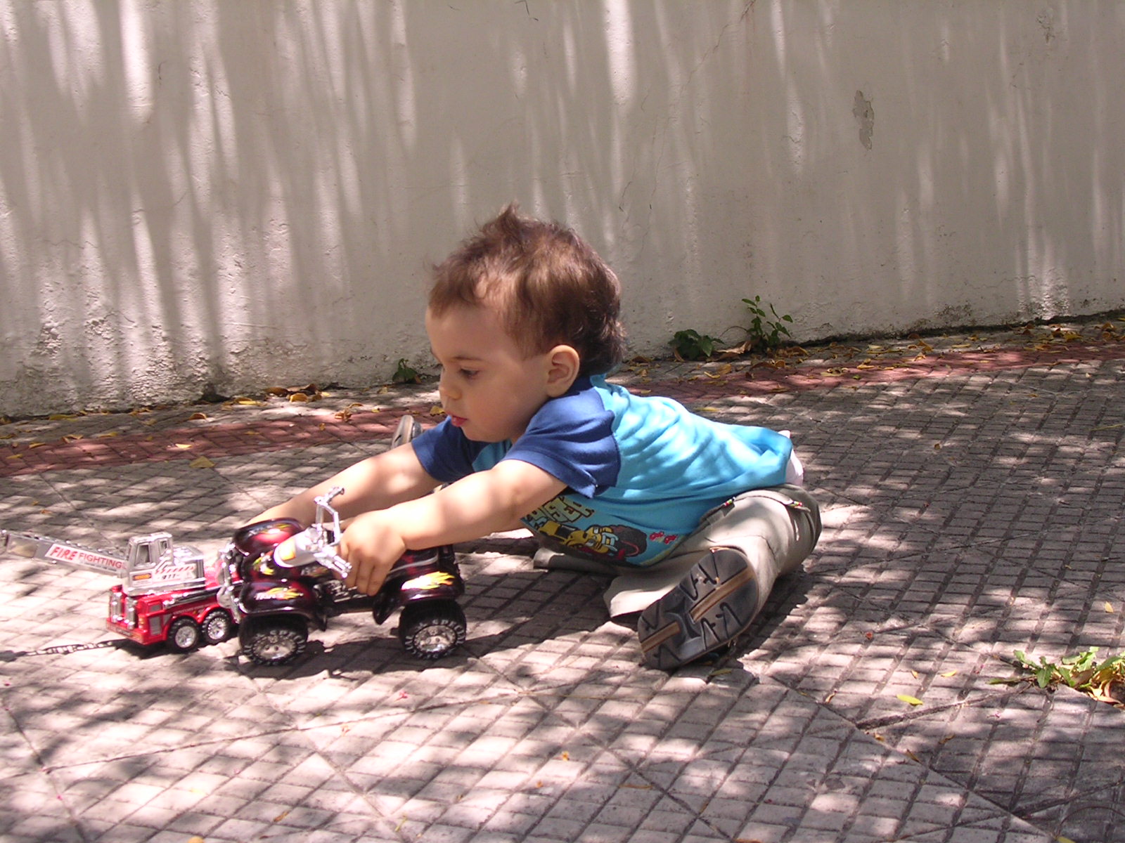 the small boy is playing with his toy truck