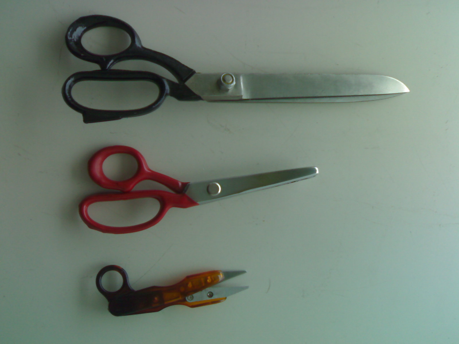 three different types of scissors, some red and one black