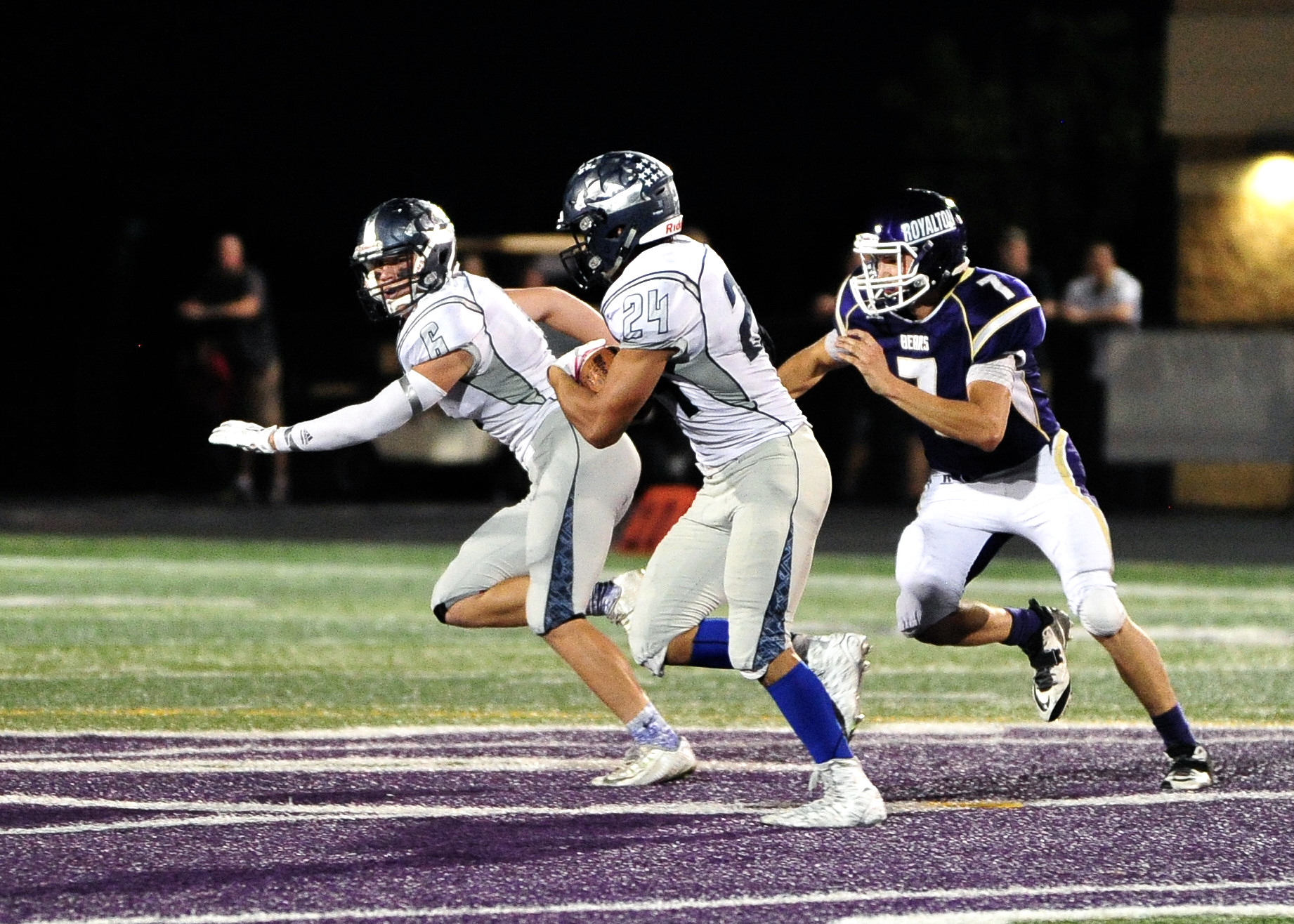 a man running on the football field wearing blue and white gear