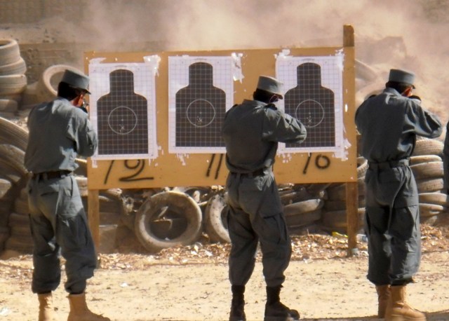 four soldiers standing in front of a target wall