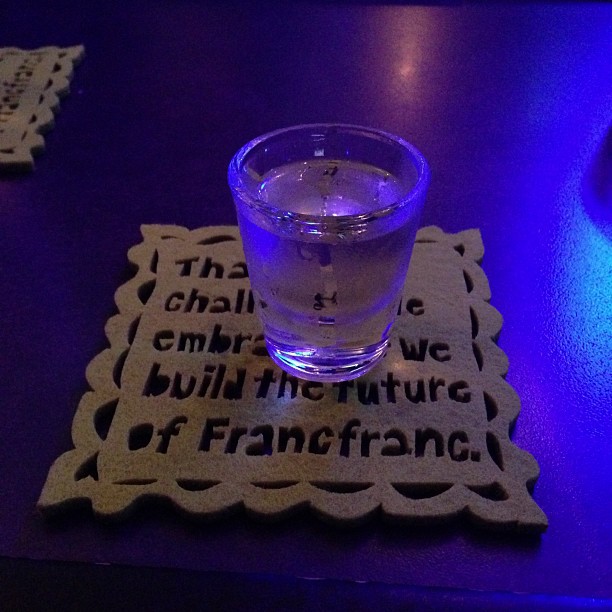 a blue light lit up a table with placemats and a drink
